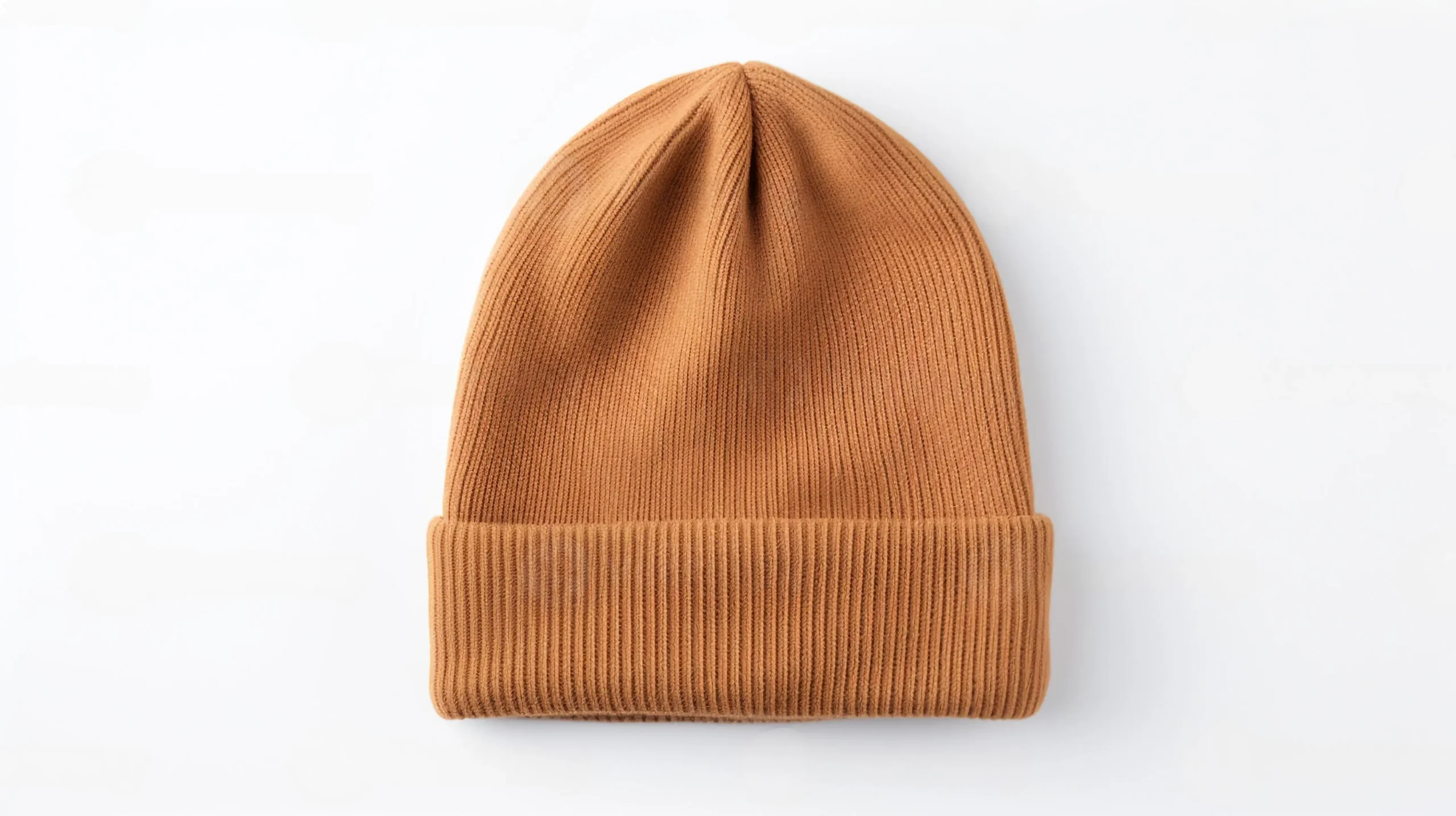 A cozy, ribbed beanie in a warm caramel shade, laid flat against a white background, showcasing its soft texture and design.