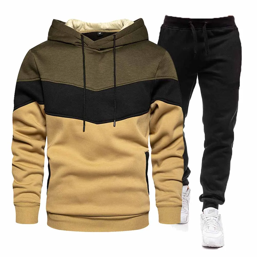 Men's color-blocked hoodie in tan, black, and olive green, paired with black joggers and white sneakers. Casual, trendy sportswear.